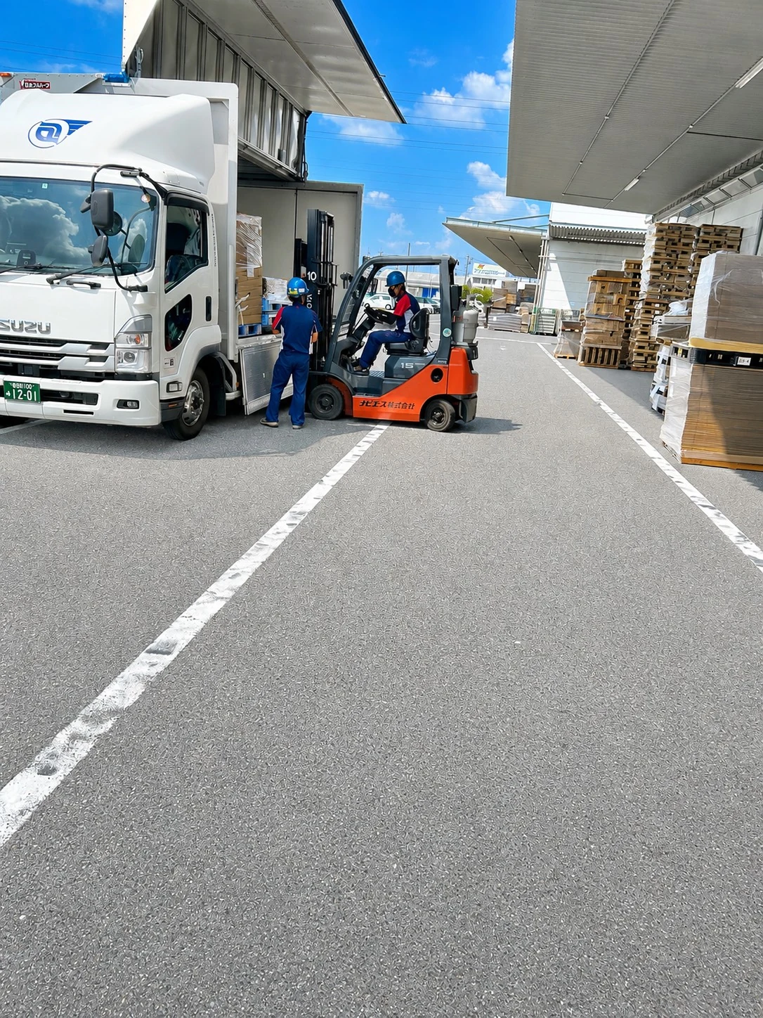段ボール製品をフォークリフトで配送トラックへ積み込む作業